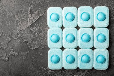 Siyah doku arka planında su yumuşatıcı haplar. Çamaşır makineleri ve bulaşık makineleri için kapsüller, kireçlenme ölçeğini engelliyor. Kopyalanacak yer.