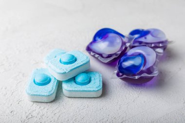 Yıkama ve yumuşatma kapsülleri. Çamaşır deterjanı çamaşır makinesinde çamaşır yıkamak için hafif mermer arka planda. Saflık kavramı. Metin için yer.