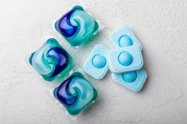 Yıkama ve yumuşatma kapsülleri. Çamaşır deterjanı çamaşır makinesinde çamaşır yıkamak için hafif mermer arka planda. Saflık kavramı. Metin için yer.