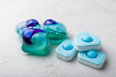 Yıkama ve yumuşatma kapsülleri. Çamaşır deterjanı çamaşır makinesinde çamaşır yıkamak için hafif mermer arka planda. Saflık kavramı. Metin için yer.