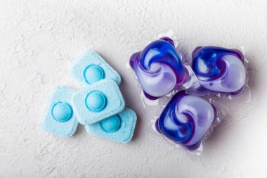 Yıkama ve yumuşatma kapsülleri. Çamaşır deterjanı çamaşır makinesinde çamaşır yıkamak için hafif mermer arka planda. Saflık kavramı. Metin için yer.