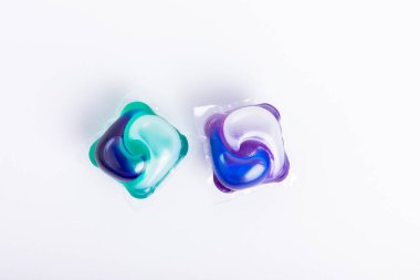 Çamaşır deterjanı yıkama kapsülleri çamaşır makinesinde çamaşır yıkamak için beyaz arka planda izole edilmiş. Saflık kavramı. Metin için yer.