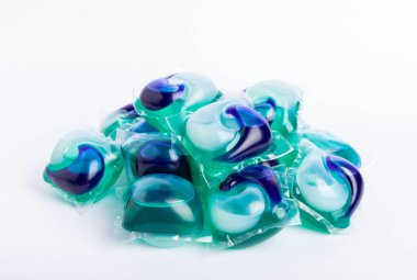 Çamaşır deterjanı yıkama kapsülleri çamaşır makinesinde çamaşır yıkamak için beyaz arka planda izole edilmiş. Saflık kavramı. Metin için yer.