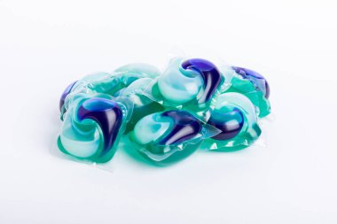 Çamaşır deterjanı yıkama kapsülleri çamaşır makinesinde çamaşır yıkamak için beyaz arka planda izole edilmiş. Saflık kavramı. Metin için yer.