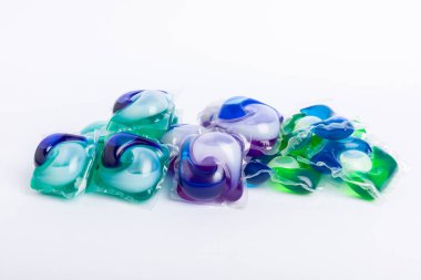 Çamaşır deterjanı yıkama kapsülleri çamaşır makinesinde çamaşır yıkamak için beyaz arka planda izole edilmiş. Saflık kavramı. Metin için yer.