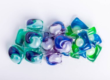 Çamaşır deterjanı yıkama kapsülleri çamaşır makinesinde çamaşır yıkamak için beyaz arka planda izole edilmiş. Saflık kavramı. Metin için yer.