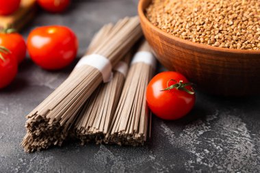 Karabuğday sobası ezmesi ve domatesli domates. Çiğ erişte. Glütensiz yemek için gerekli malzemeler. Kurutulmuş karabuğday sobalı erişte. Geleneksel Japon yemekleri. Sağlıklı yiyecekler. Kopyalanacak yer.