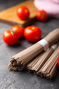 Karabuğday sobası ezmesi ve domatesli domates. Çiğ erişte. Glütensiz yemek için gerekli malzemeler. Kurutulmuş karabuğday sobalı erişte. Geleneksel Japon yemekleri. Sağlıklı yiyecekler. Kopyalanacak yer.