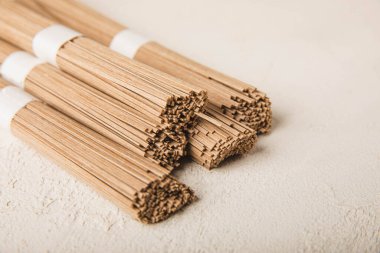 Beyaz arka planda karabuğday sobalı makarna. Çiğ erişte. Glütensiz yemek için gerekli malzemeler. Kurutulmuş karabuğday sobalı erişte. Geleneksel Japon yemekleri. Sağlıklı yiyecekler. Kopyalanacak yer.