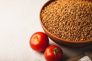 Kiraz domatesli karabuğday ve dokulu arkaplanda karabuğday çorbası. Çiğ karabuğday. Glüten içermeyen mısır gevreği. Sağlıklı yemek. Kopyalanacak yer.