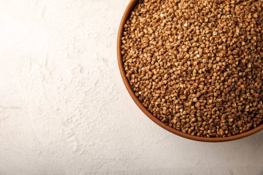 Kabın içinde dokulu bir arka planda karabuğday. Çiğ karabuğday. Glüten içermeyen mısır gevreği. Sağlıklı yemek. Kopyalanacak yer.