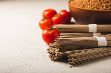 Karabuğday sobası ezmesi ve domatesli domates. Çiğ erişte. Glütensiz yemek için gerekli malzemeler. Kurutulmuş karabuğday sobalı erişte. Geleneksel Japon yemekleri. Sağlıklı yiyecekler. Kopyalanacak yer.