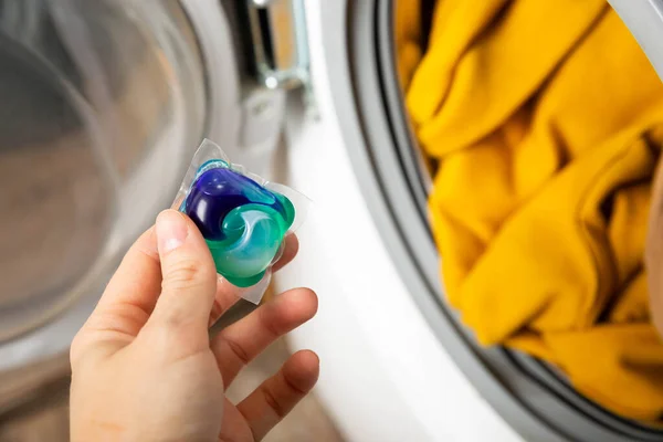 캡슐을 세탁기에 클로즈업 세탁용 캡슐에 빨래를 깨끗하게 — 스톡 사진