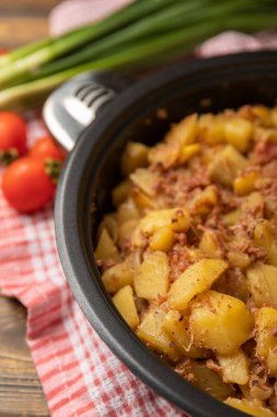 Kahverengi bir ahşap üzerinde haşlanmış domuz eti, patates ve soğan. Sebzeli kompozisyon. Kopyalanacak yer. Mesaj için yer. Kızarmış patates tarifi.