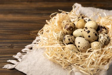 Kahverengi desenli arka planda bıldırcın yumurtası. Organik yiyecek. Mesaj için yer. taze yumurta