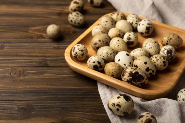 Kahverengi desenli bambu tabaktaki bıldırcın yumurtaları. Organik yiyecekler. Mesaj için yer. taze yumurta