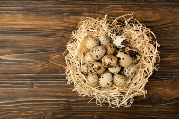 Kahverengi desenli arka planda bıldırcın yumurtası. Organik yiyecek. Mesaj için yer. taze yumurta