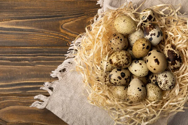 Kahverengi desenli arka planda bıldırcın yumurtası. Organik yiyecek. Mesaj için yer. taze yumurta