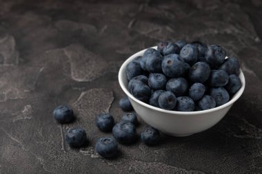 Siyah desenli arka planda seramik bir kasede yaban mersini. Olgun ve taze yaban mersini. Vitaminler. Sağlıklı yiyecekler. Sulu böğürtlen. Boşluğu kopyala. Mesaj için yer