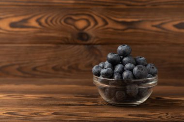 Kahverengi dokuya sahip seramik bir kasede yabanmersini. Olgun ve taze yaban mersini. Vitaminler. Sağlıklı yiyecekler. Sulu böğürtlen. Boşluğu kopyala. Mesaj için yer