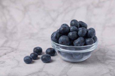 Hafif desenli arka planda seramik bir kasede yaban mersini. Olgun ve taze yaban mersini. Vitaminler. Sağlıklı yiyecekler. Sulu böğürtlen. Boşluğu kopyala. Mesaj için yer