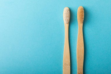 Mavi arka planda çevre dostu bambu diş fırçası. Doğal organik ürünlerden banyo için kozmetik ürünler konsepti. Düz konum, üst görünüm, kopyalama alanı. Ağız bakımı. Çevre dostu
