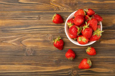 Kahverengi desenli bir kasede taze olgun çilekler. Vejetaryen organik böğürtlen. Sağlıklı yiyecek.