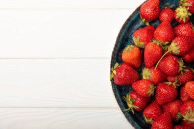 Beyaz ahşap bir arka planda taze olgun çilekler. Vejetaryen organik böğürtlen. Sağlıklı yiyecek. Vitamin.