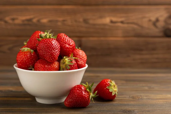 Kahverengi desenli bir kasede taze olgun çilekler. Vejetaryen organik böğürtlen. Sağlıklı yiyecek.