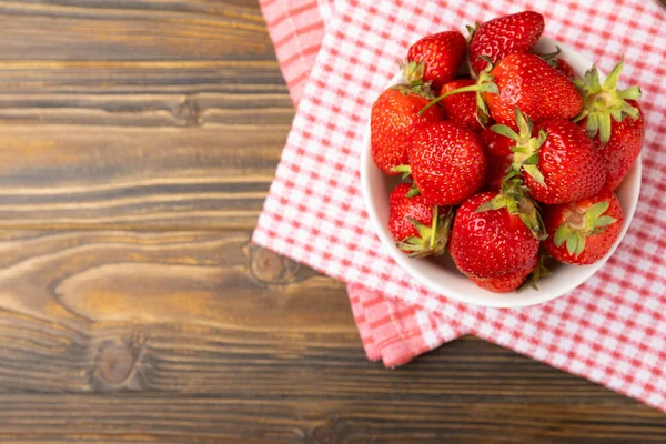 Kahverengi desenli bir kasede taze olgun çilekler. Vejetaryen organik böğürtlen. Sağlıklı yiyecek.