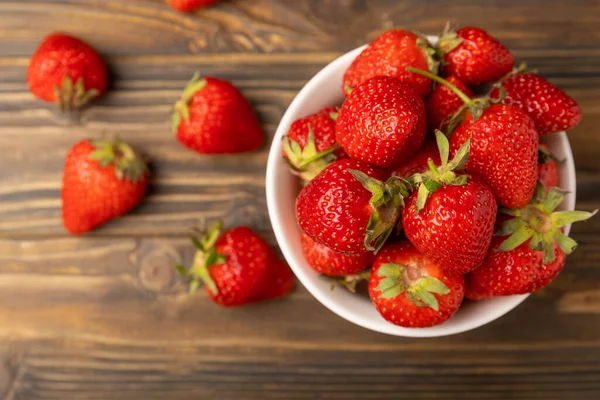 Kahverengi desenli bir kasede taze olgun çilekler. Vejetaryen organik böğürtlen. Sağlıklı yiyecek.