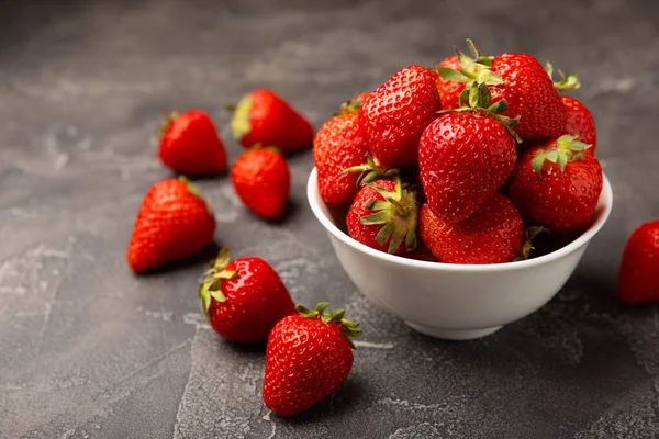 Siyah desenli bir tabakta taze olgun çilekler. Vejetaryen organik böğürtlen. Sağlıklı yiyecek. Vitamin.