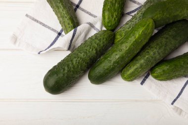 Beyaz ahşap üzerinde taze salatalıklar. Vejetaryen organik sebzeler. Salata için. Sağlıklı yiyecek. Boşluğu kopyala. Metin için yer