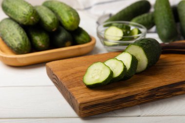 Dilimlenmiş salatalık. Beyaz dokuda taze salatalık. Salata için dilimlenmiş salatalık dilimleri. Vejetaryen organik sebzeler. Sağlıklı yiyecekler.