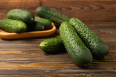 Kahverengi ahşap üzerinde taze salatalıklar. Vejetaryen organik sebzeler. Salata için. Sağlıklı yiyecek. Boşluğu kopyala. Metin için yer