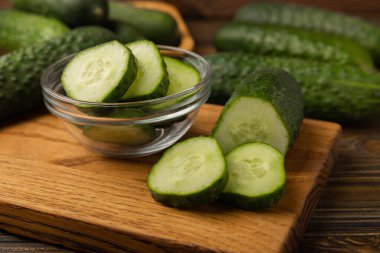 Dilimlenmiş salatalık. Kahverengi dokuda taze salatalık. Salata için dilimlenmiş salatalık dilimleri. Vejetaryen organik sebzeler. Sağlıklı yiyecekler.