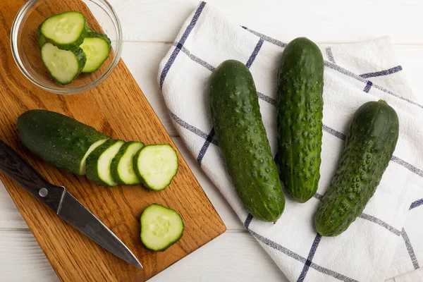 Sliced cucumber.Fresh cucumbers on a white texture background. Sliced cucumber slices for salad.Vegetarian organic vegetables.Healthy food.Copy space.Place for text