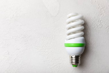 LED lambaların enerji verimliliği kavramı. Gri çimento arka planında kompozisyon. Ekonomik ve çevre dostu bir ampul konsepti kullanın. Çevre. Düz katman. Boşluğu kopyala. Mocap