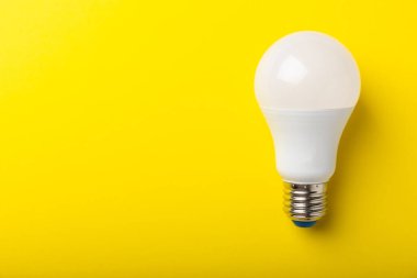 LED lamba enerji verimliliği kavramı. Sarı arka plan bileşimi. Ekonomik ve çevre dostu ampul kavramını kullanın. Eko. Düz katman. Boşluğu kopyala. MOCKUP