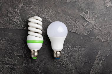 Elektrik ampulleri. Enerji verimliliği kavramı. LED lamba parlak lambaya karşı. Siyah mermer arka planda kompozisyon. Ekonomik ve çevre dostu bir ampul kavramı kullan.