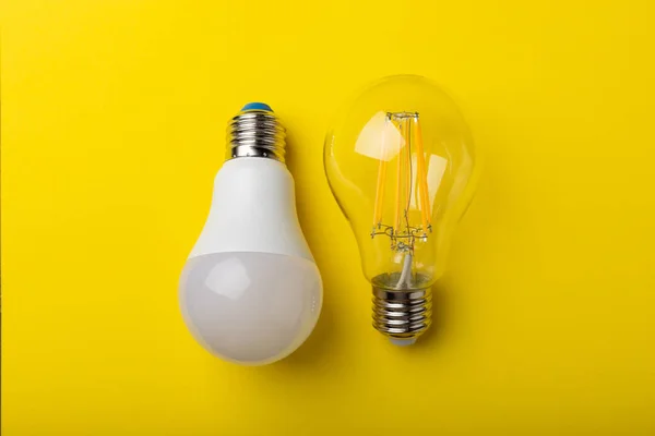 Electric light bulbs. the concept of energy efficiency. LED lamp vs incandescent lamp. Composition on a yellow background. Use an economical and environmentally friendly light bulb concept.