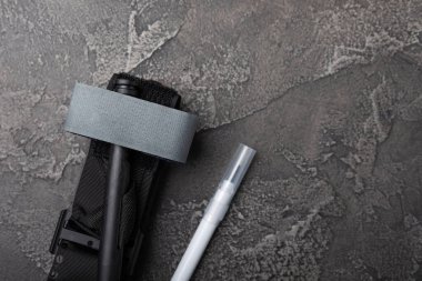 Siyah desenli bir tahtanın üzerindeki kanı durdurmak için tıbbi turnike. Kopyalanacak yer. Yukarıdan bak. düz döşek.