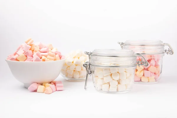 Marshmallow in glass jar and ceramic bowl isolated on white background. White and fruit marshmallows. Sweets and snacks for a snack.
