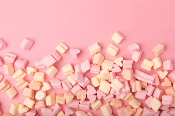 Fruit marshmallows in bulk on a pink background.Sweets and snacks for a snack.Chewy candy close-up.Space for copy.Place for text.