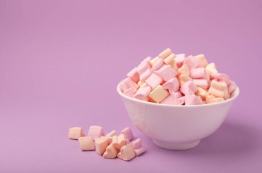Leylak arkaplanda marshmallow kaseleri. Kapalı kapaklı çilek aromalı şeker, partiler için abur cubur, kahve ve kakao. Kış yiyeceği konsepti..