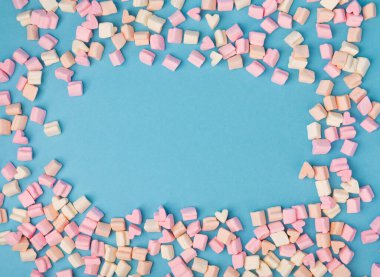 Mavi bir arka planda gevşek meyveli şekerlemeler. Atıştırmalık için tatlı ve atıştırmalıklar. Yakın plan şekerleme. Mesaj için yer..