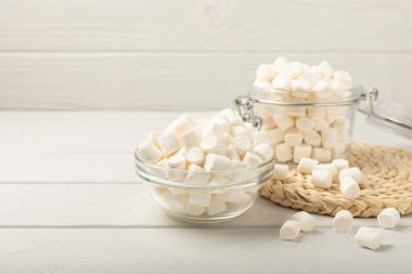 Cam bir kasede şekerlemeler ve beyaz desenli bir masada kavanoz. Atıştırmalık tatlı ve atıştırmalıklar. Yakın plan şekerleme..