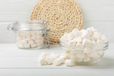 Cam bir kasede şekerlemeler ve beyaz desenli bir masada kavanoz. Atıştırmalık tatlı ve atıştırmalıklar. Yakın plan şekerleme..