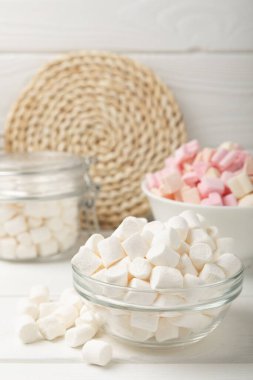 Bir sürü farklı marşmelov kaselerde ve kavanozlarda beyaz desenli bir ahşap üzerinde. Beyaz ve meyveli lokum. Atıştırmalık tatlı ve atıştırmalıklar. Şekerleri yakından çiğniyor. Uzayı kopyala Metin için yer.