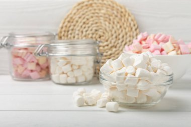 Bir sürü farklı marşmelov kaselerde ve kavanozlarda beyaz desenli bir ahşap üzerinde. Beyaz ve meyveli lokum. Atıştırmalık tatlı ve atıştırmalıklar. Şekerleri yakından çiğniyor. Uzayı kopyala Metin için yer.